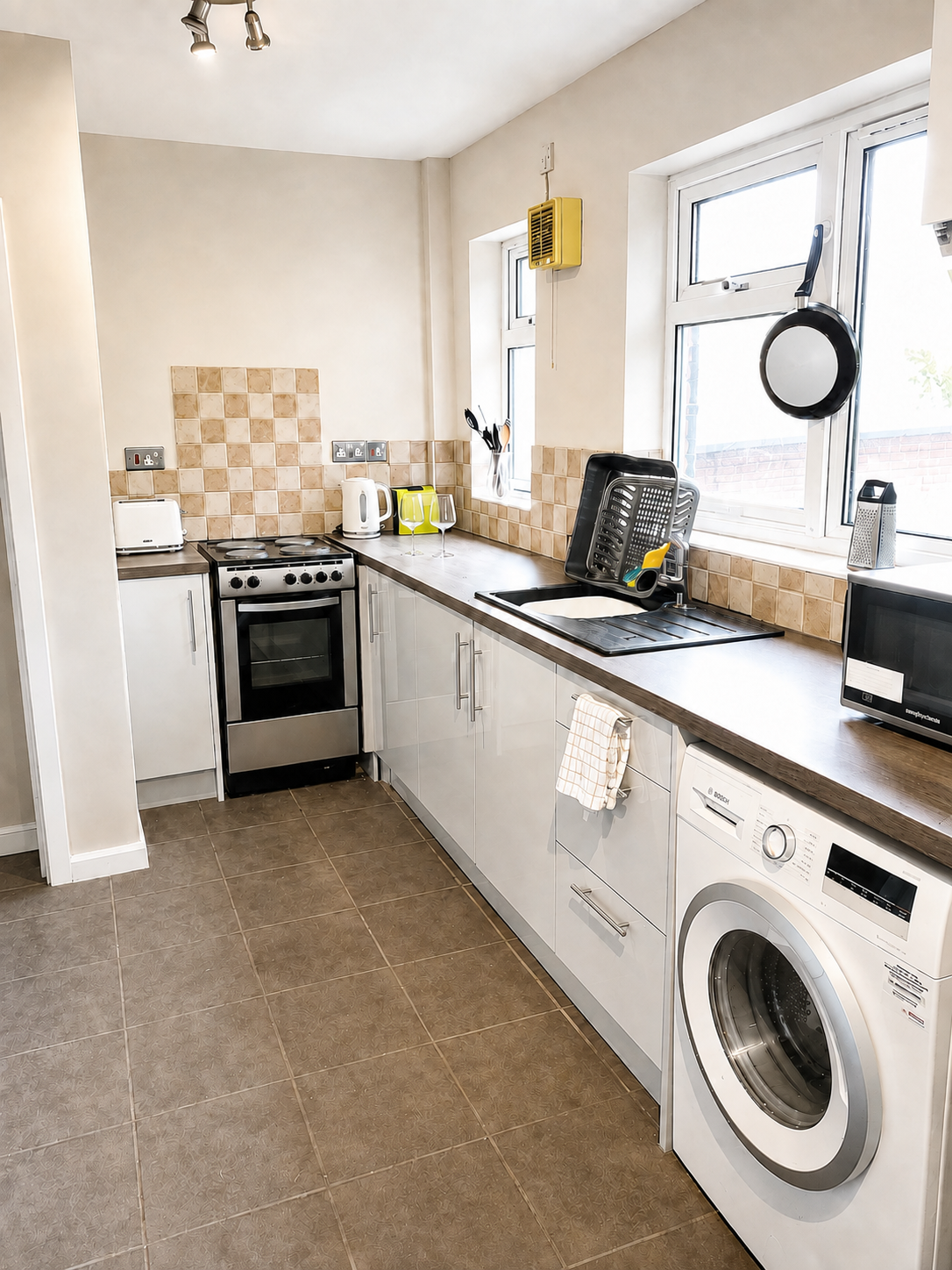 Shared kitchen with cooker, worktops, sink and washing machine